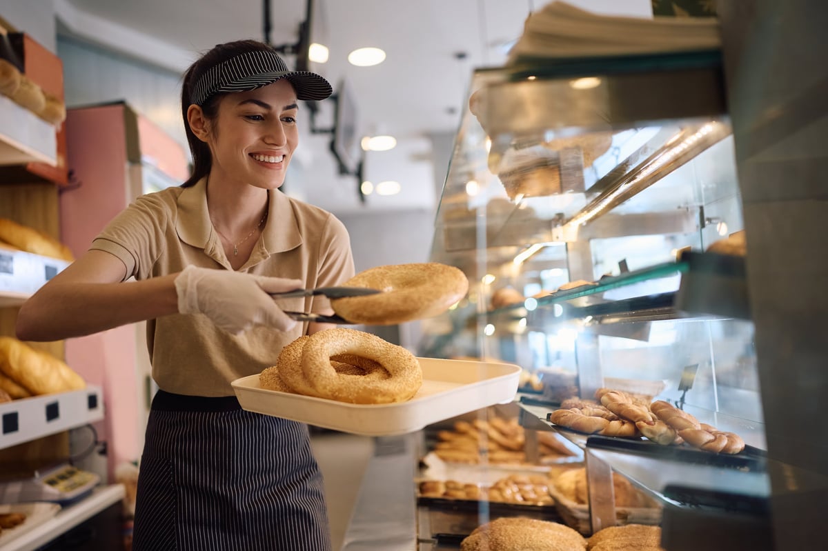 Young woman arranging freshly baked pastries